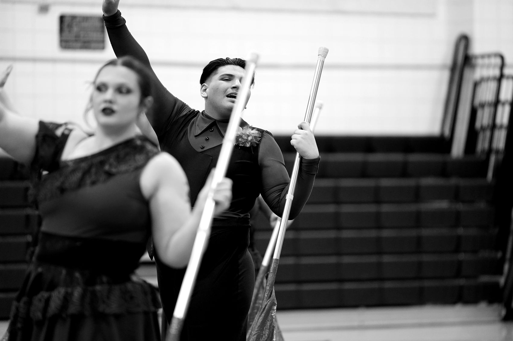 Morgan and a teammate holding flag poles upright in a held position.