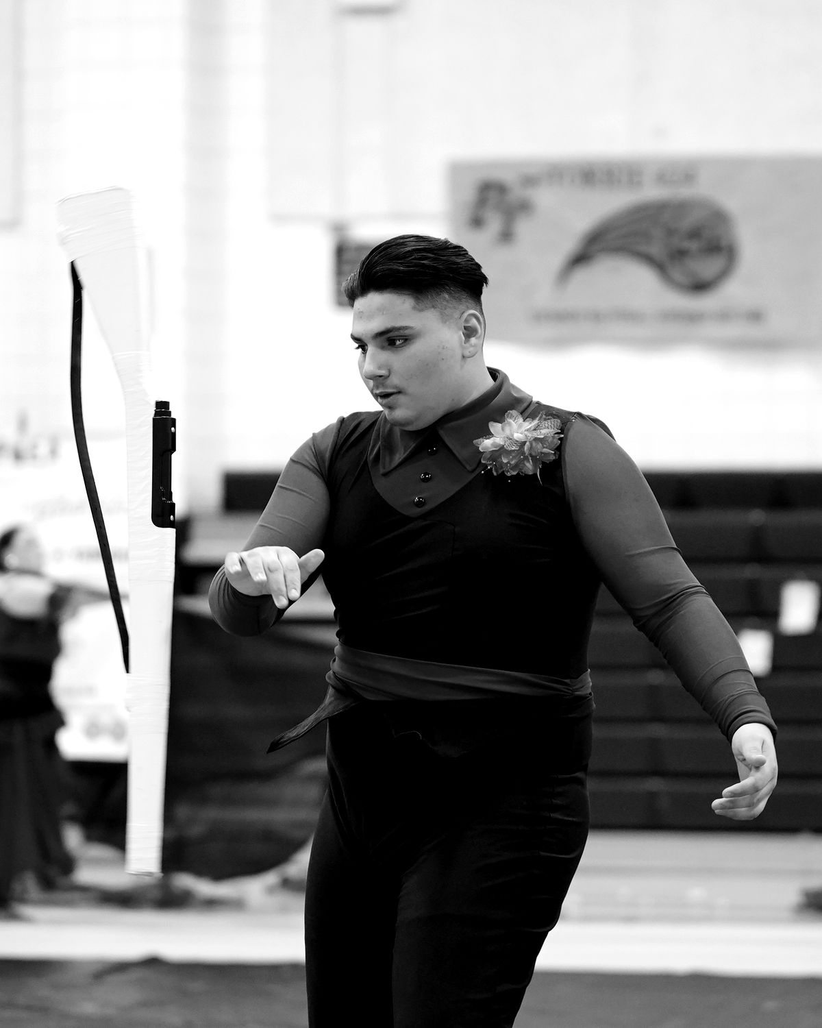 Morgan in uniform on the competition floor, tracking a rifle he has just thrown.